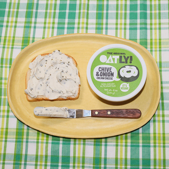 Oatly Chive and Onion Cream Cheese spread on a piece of white bread